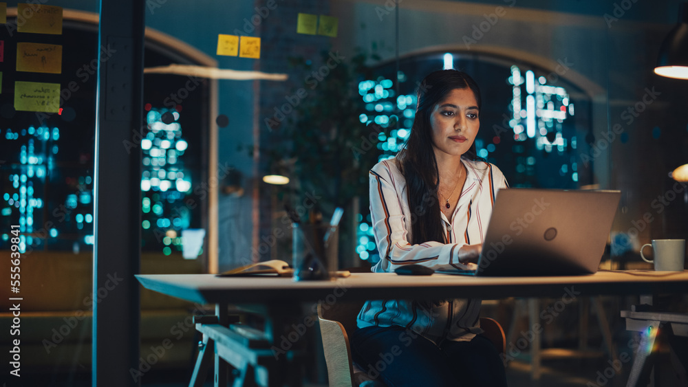 Beautiful Female in a Striped White Shirt Sitting at a Desk in Creative Office, Working on Tasks on 