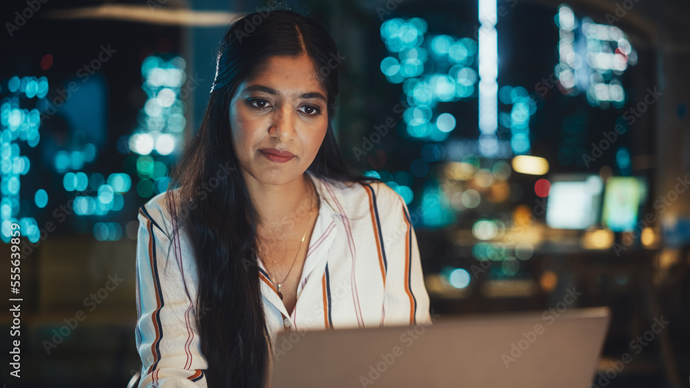 Close Up Portrait of a Happy Indian Manager Sitting at a Desk in Creative Office. Young Stylish Fema