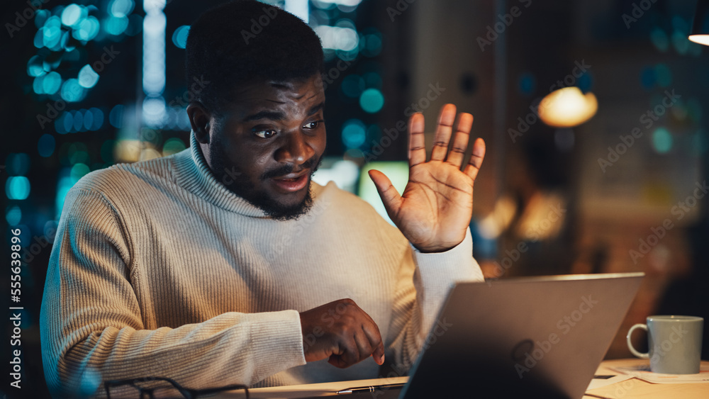 Portrait of a Handsome Black Project Manager Making a Video Call on Laptop Computer in an Evening Of