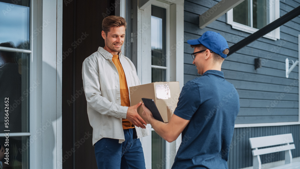 Handsome Young Homeowner Receiving an Awaited Parcel from a Cheerful Courier. Postal Service Worker 