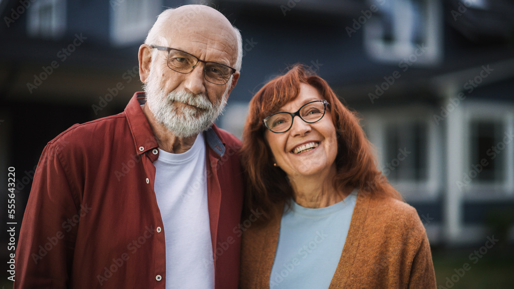 Cheerful Old Couple Standing Outdoors in Their Suburbs Area Home, Embracing Each Other. Adults in Li