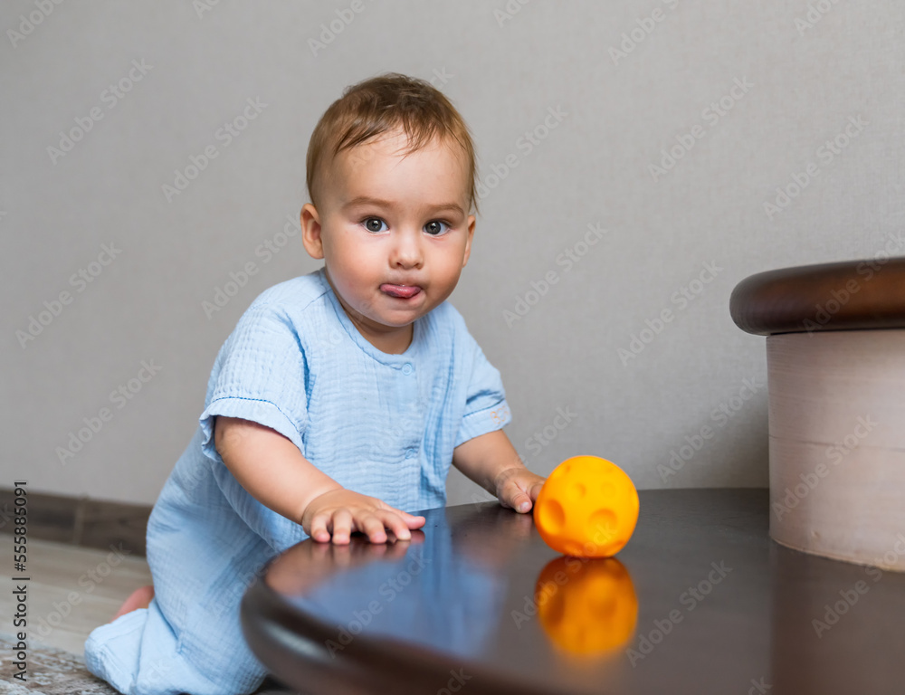 Cute kid playing on stairs inside house. Baby boy playing with colorful toy.