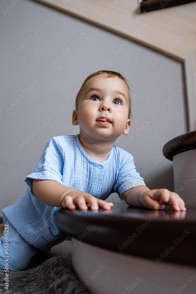 Kid playing at the stair. Foyer and living room interior. Home safety for toddler.