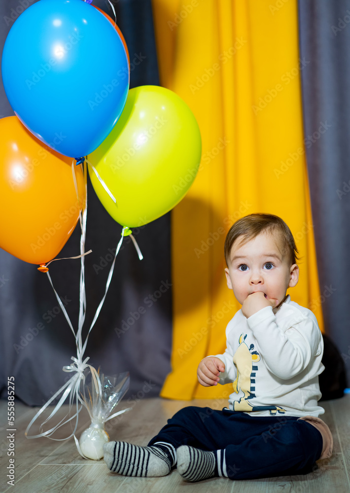 Happy baby boy with bunch of balloons. Baby boy celebrating first birthday