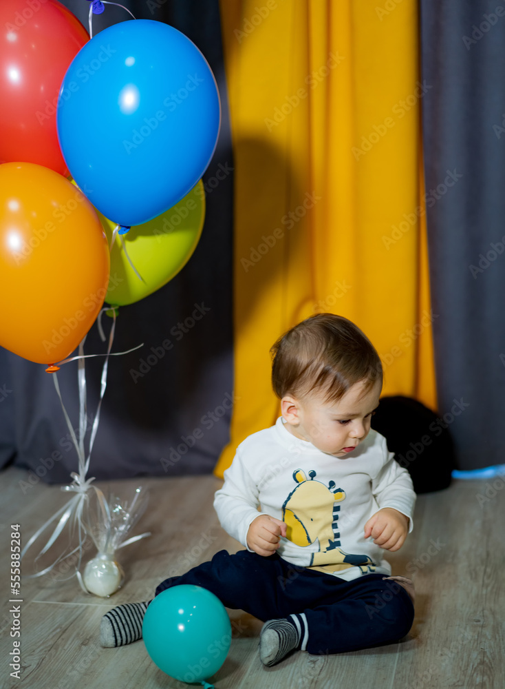 带着彩色气球的男婴快乐。男婴庆祝一岁生日