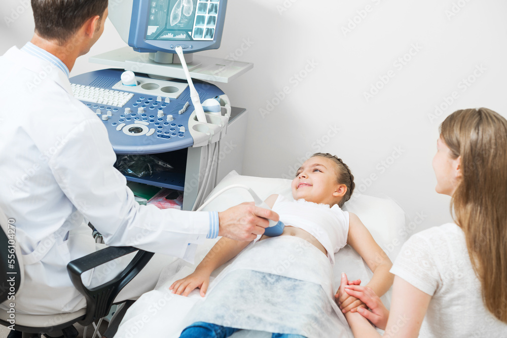 Doctor examines little patient abdomen at hospital