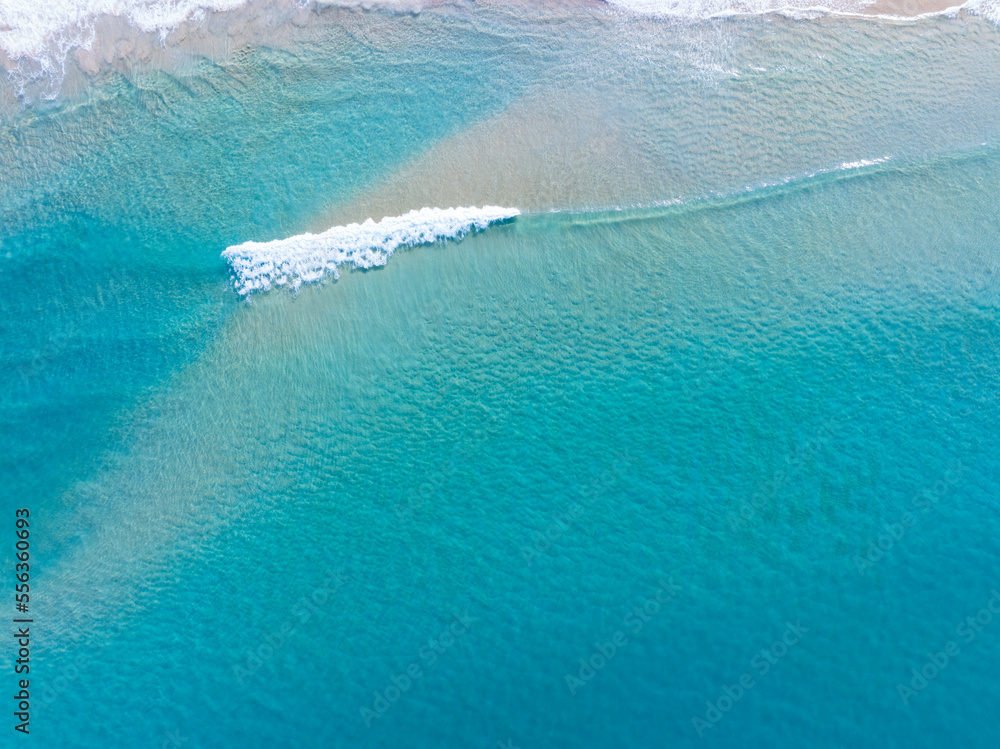 美丽的海浪水面，海滩沙海岸和波浪白色泡沫夏季阳光明媚的一天