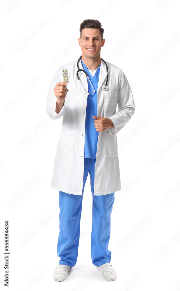 Male doctor with vitamins on white background