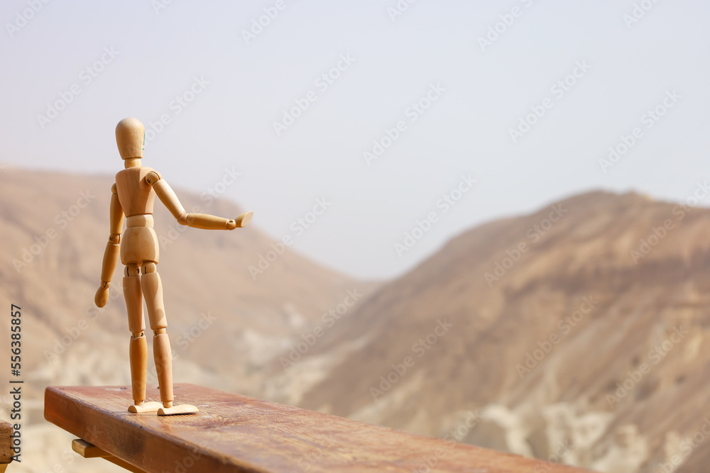 Wooden mannequin on fence in desert