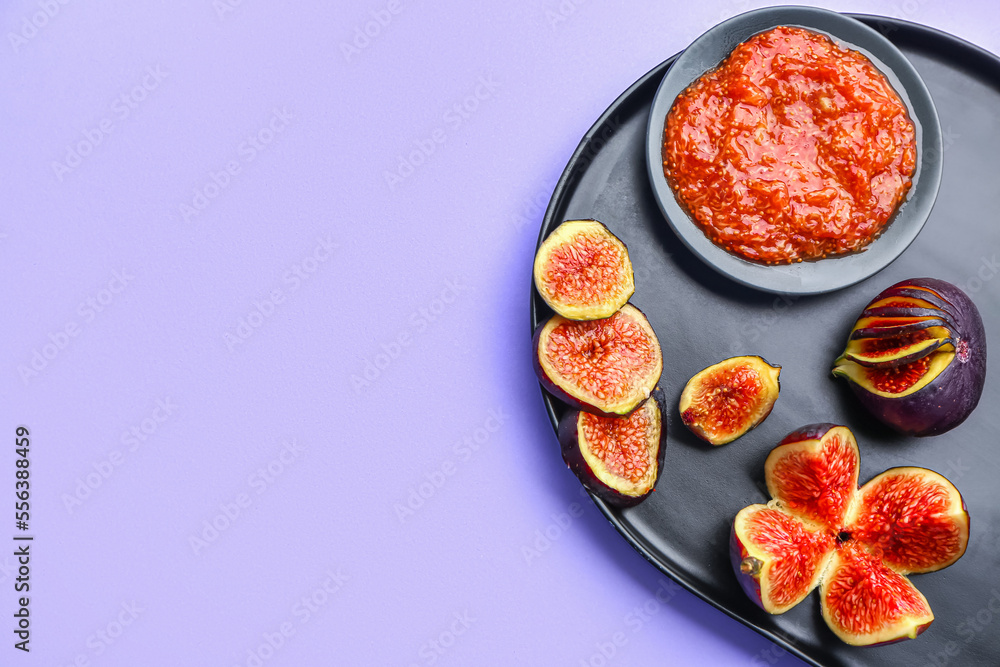 Plate with sweet figs and puree on lilac background