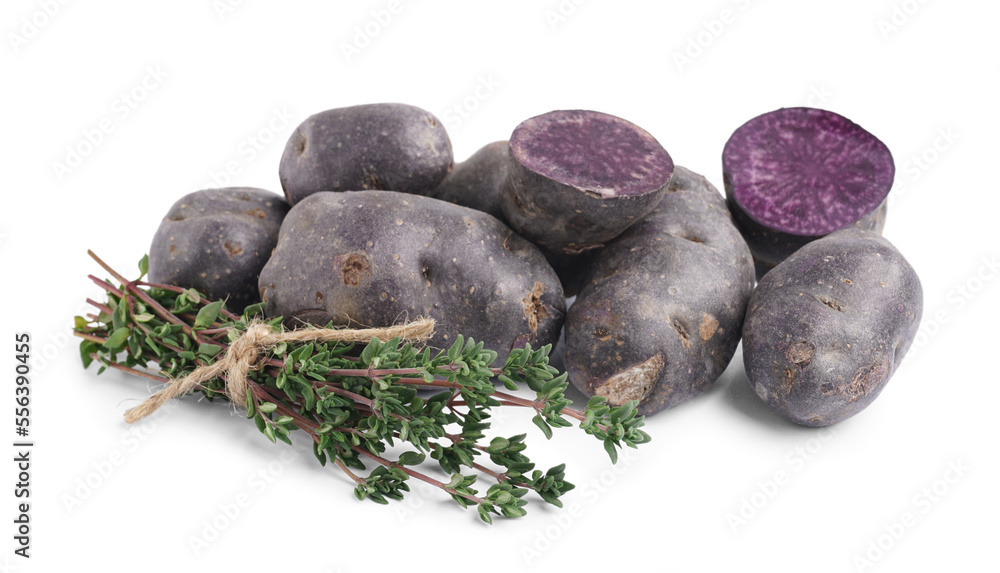 Heap of raw purple potatoes and herbs on white background