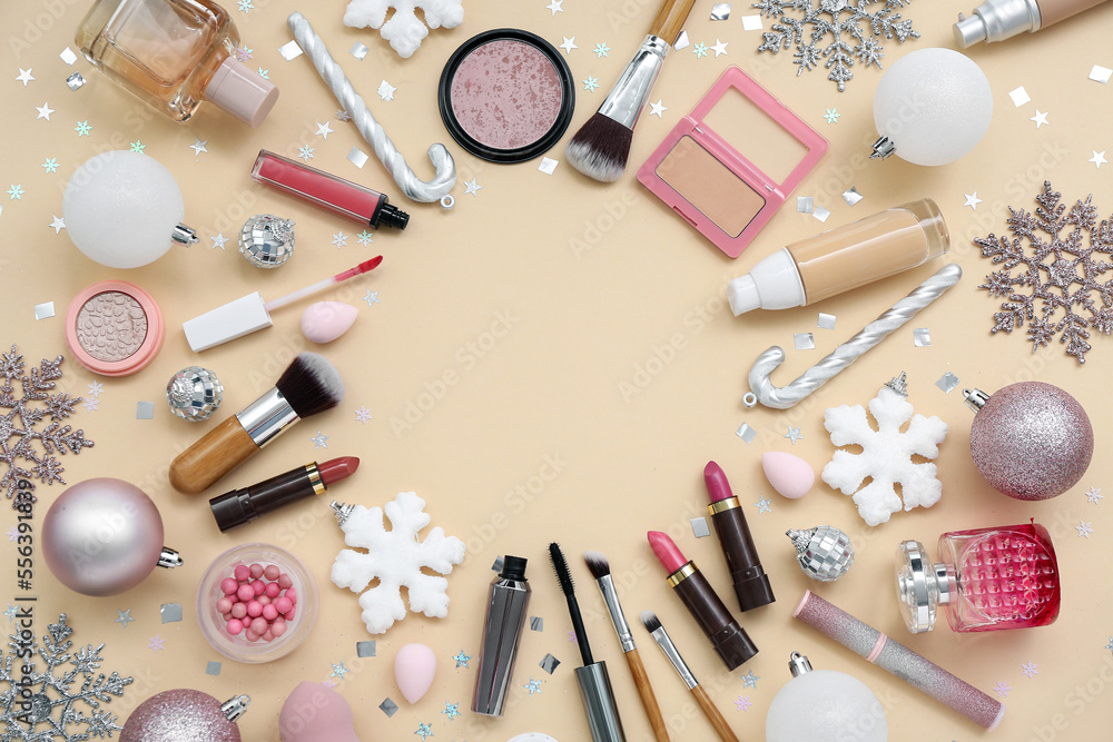 Frame made of different cosmetics, makeup accessories and Christmas decorations on color background