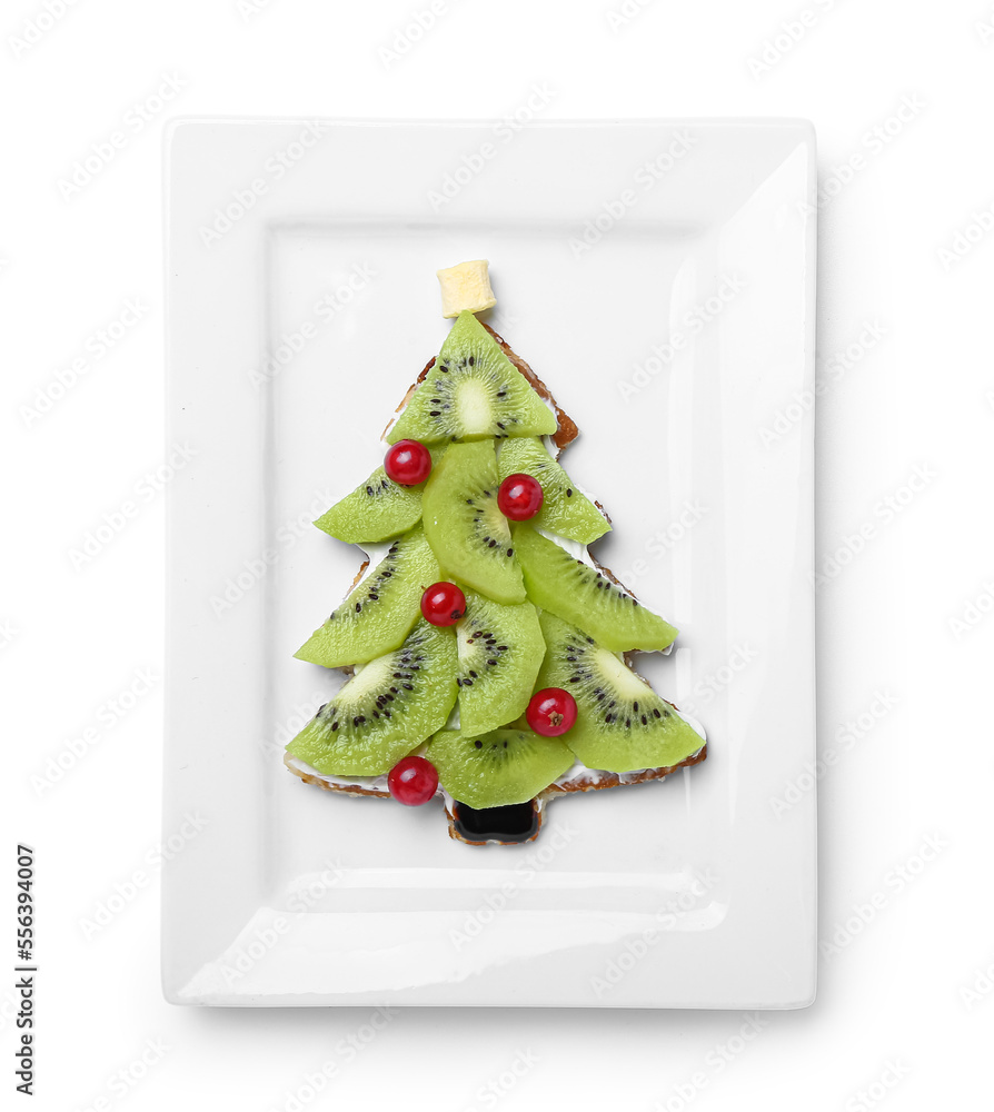 Plate of tasty pancake in shape of Christmas tree with fruits on white background