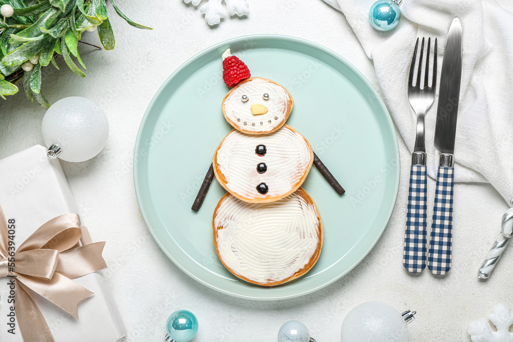 Composition with plate of tasty snowman pancakes, Christmas gift and decorations on light background