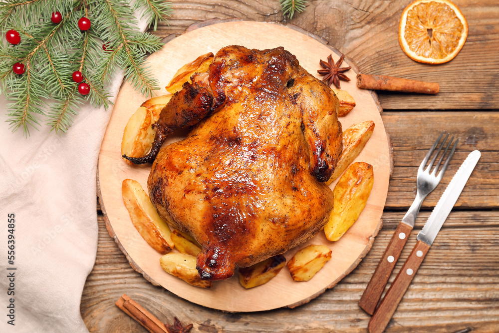 Christmas table setting with tasty chicken and potato on wooden background