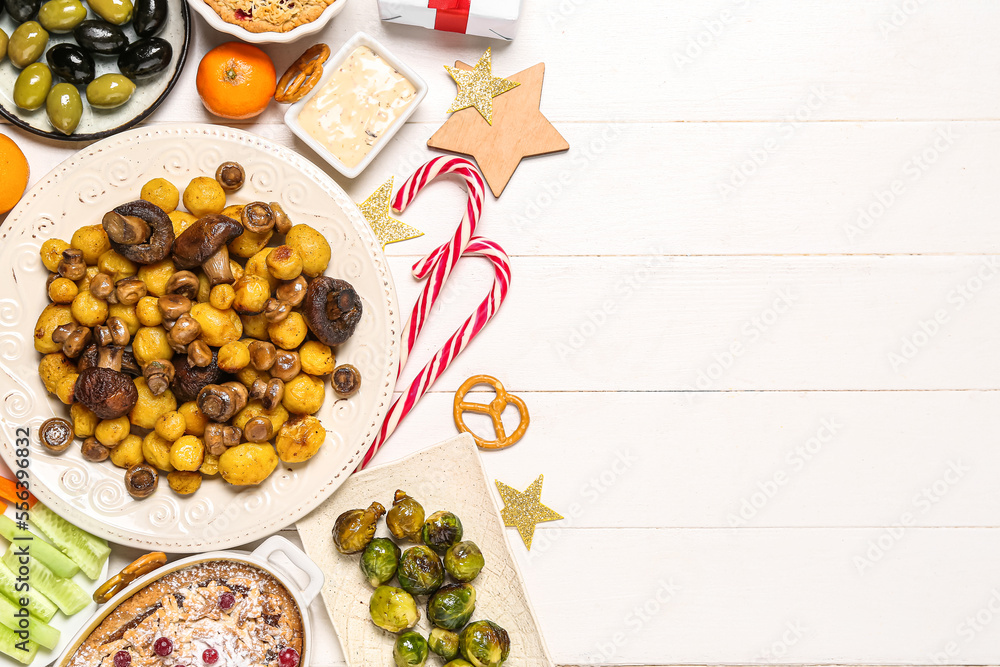 Christmas table setting with tasty food and decor on white wooden background