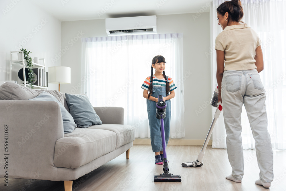 Caucasian beautiful mother cleaning house with young kid daughter. 