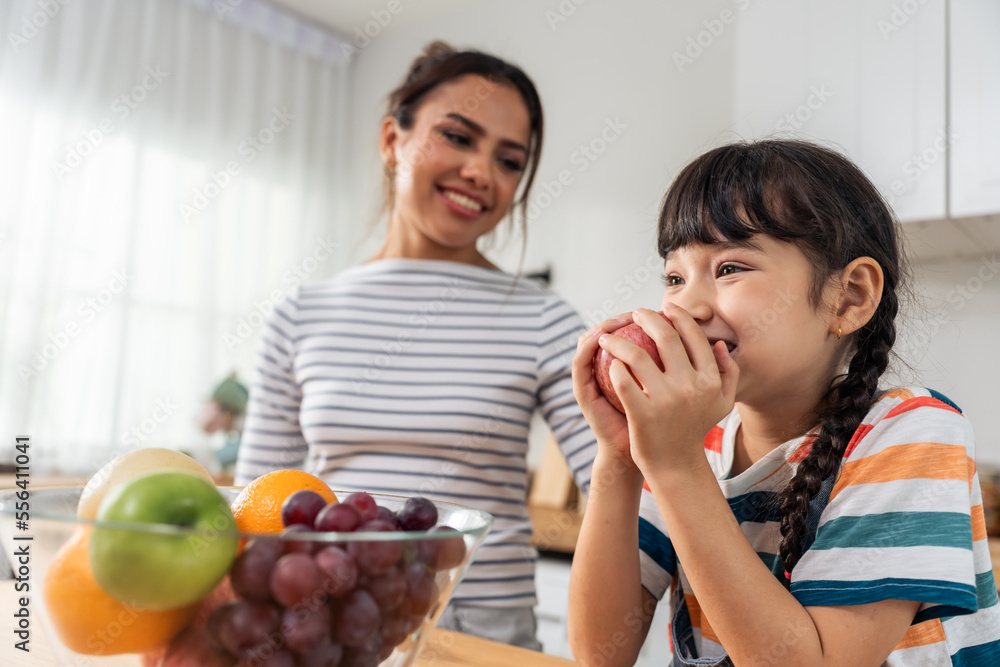 亚洲母亲教导和激励年轻女孩吃健康的水果。