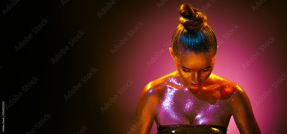 Fashion art portrait. Model girl in colorful bright sparkles, gold and pink skin, neon lights  posin