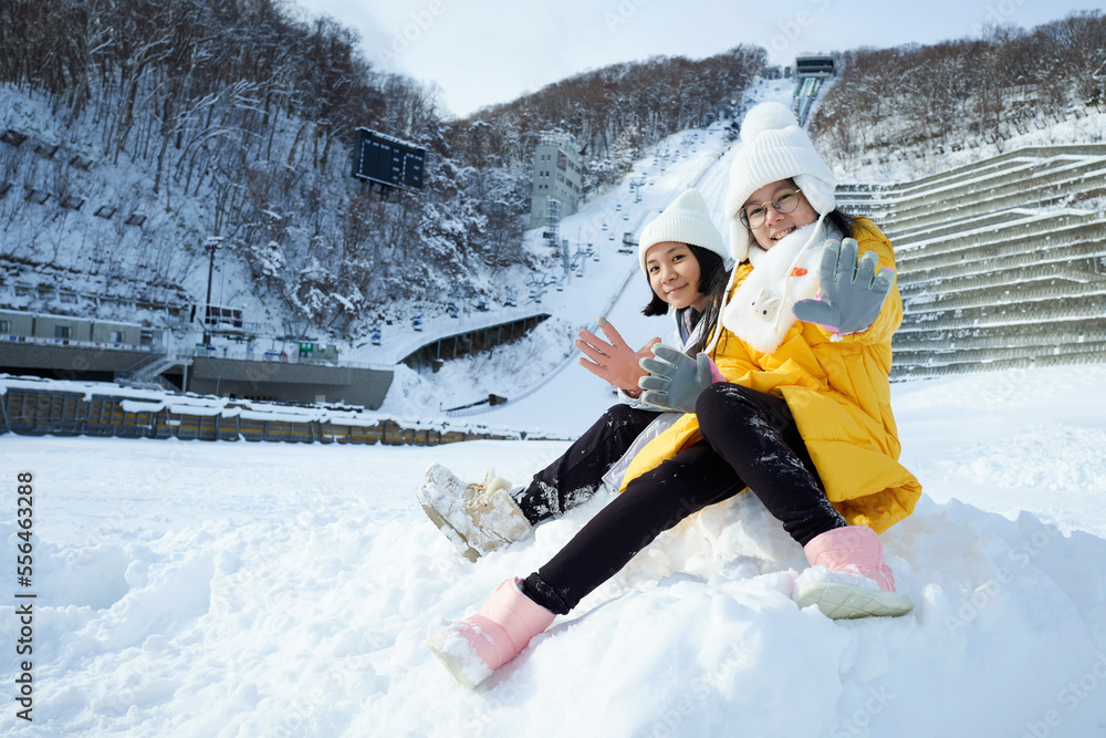 美丽的亚洲两姐妹微笑着，在北海道的雪冬季节旅行快乐