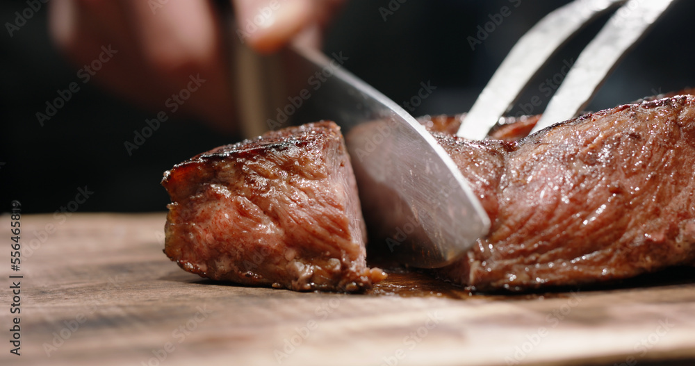 Juicy freshly grilled steak. Big piece of tasty meat cut. Macro shot of delicious meal on chefs pre