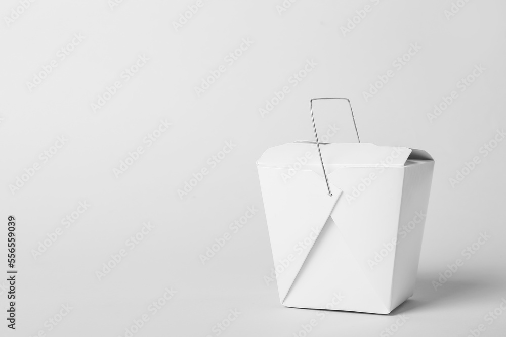 Paper box with Asian food on light background