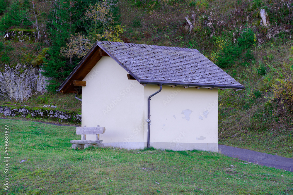 Beautiful autumn landscape at Axalp, Canton Bern, with cabin and empty wooden bench on a sunny autum