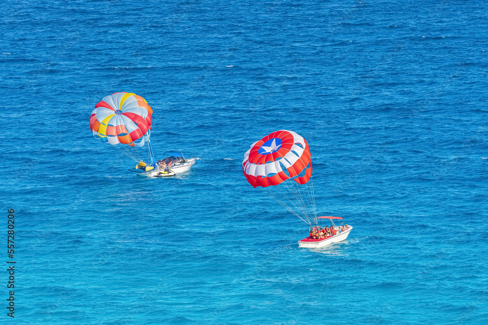 Parasailing towed behind a boat in the Caribbean sea, tropical Ocean, Vacation Concept, Cancun, Mexi