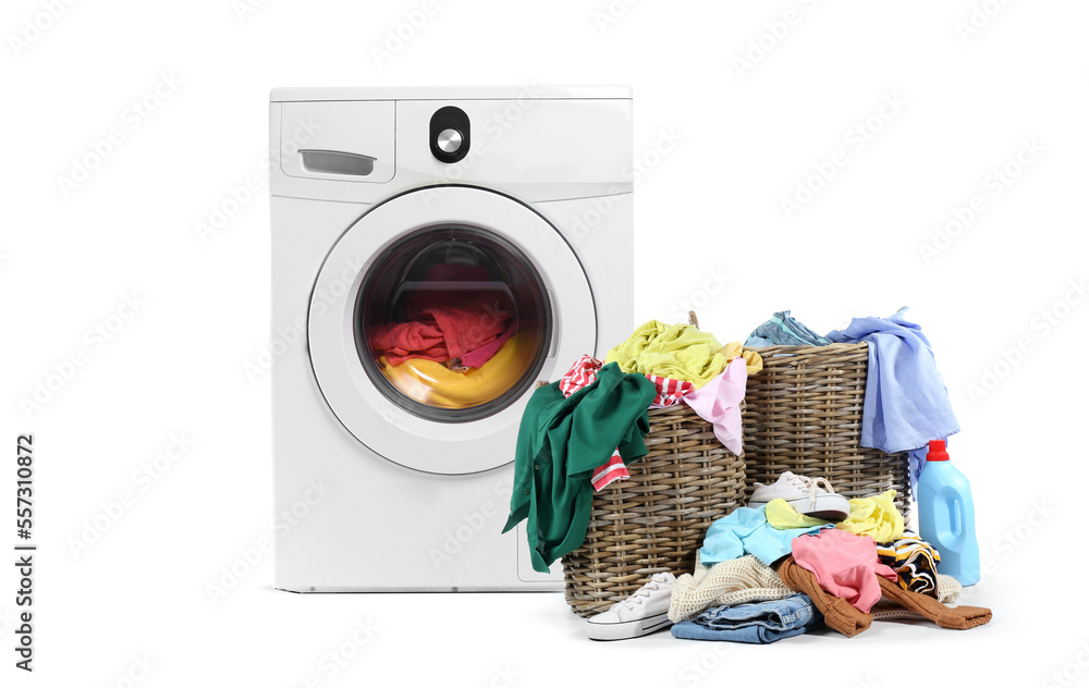 Modern washing machine with dirty clothes in laundry basket on white background