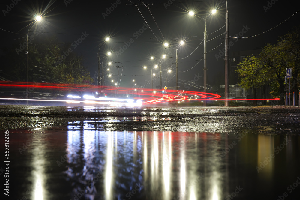 潮湿的道路和夜晚照亮的城市里发光的灯光