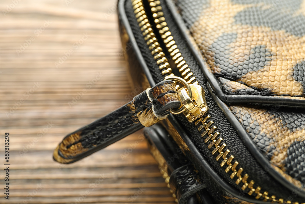 Handbag with metal zipper on wooden background, closeup