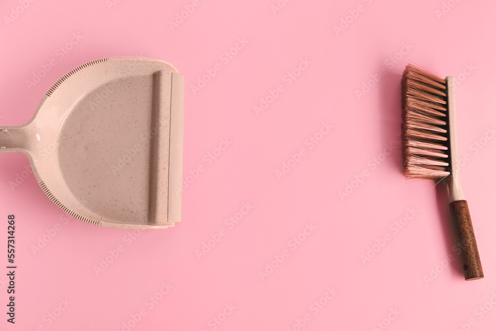 Dustpan and brush on pink background