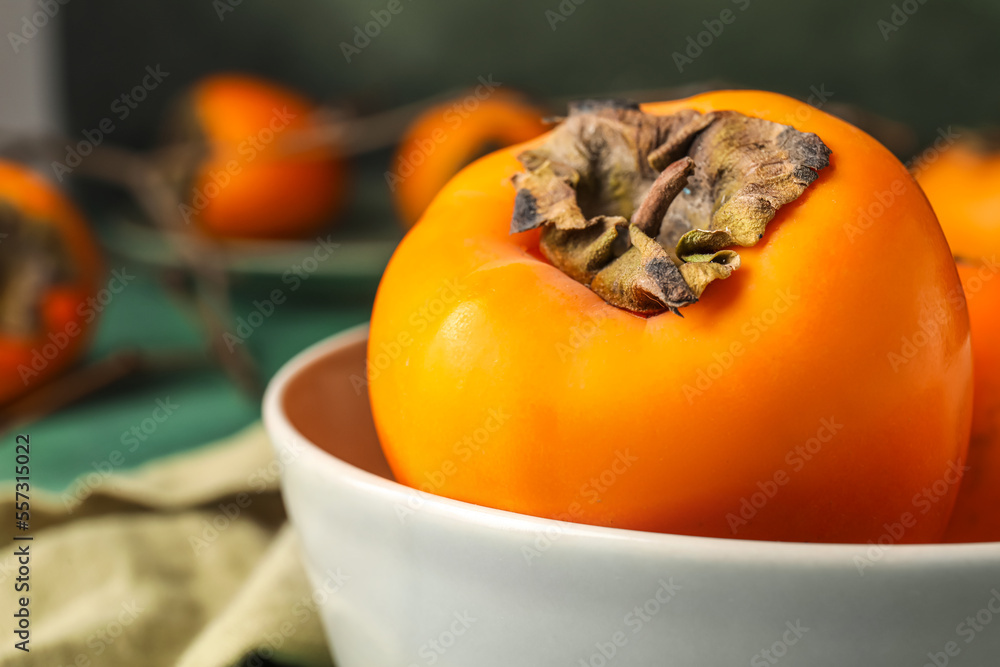 Bowl with ripe persimmon, closeup