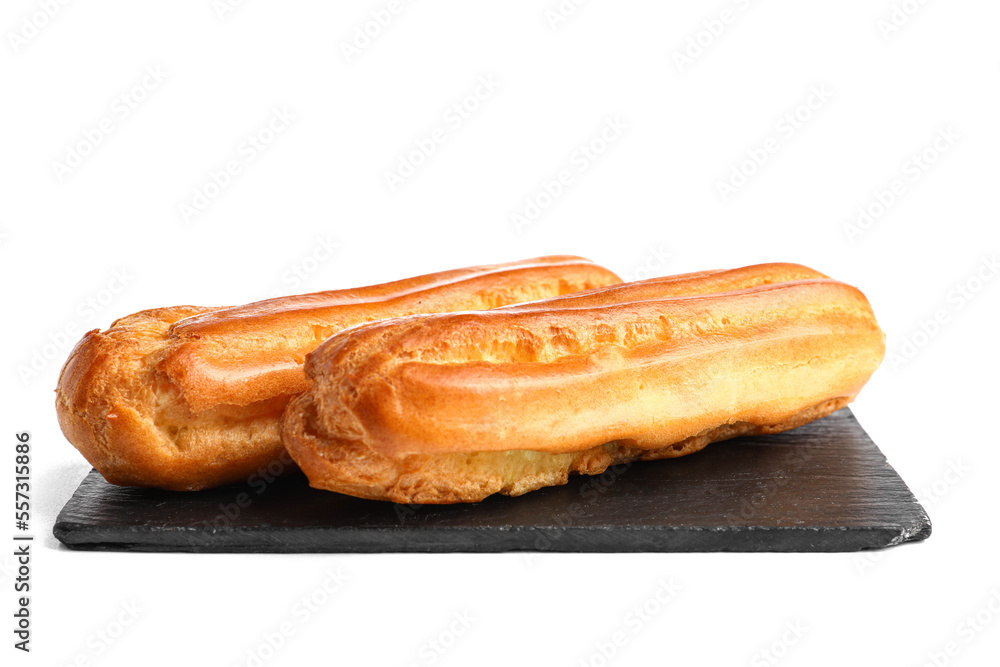 Slate board with tasty eclairs on white background