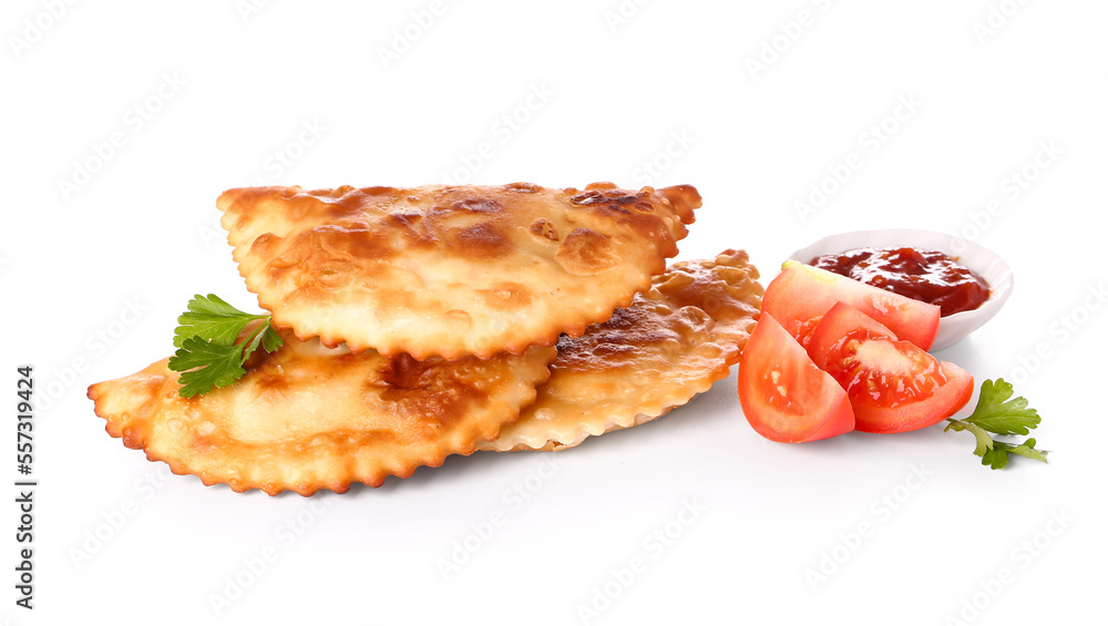 Tasty chebureks with tomatoes and sauce on white background