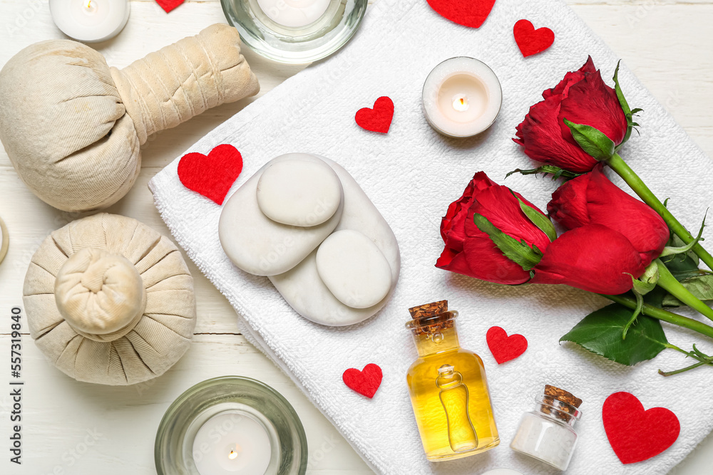 Spa composition for Valentines Day with stones, roses and candles on white wooden background