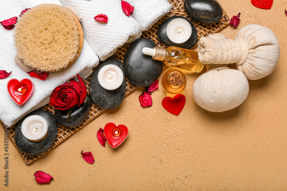 Spa composition for Valentines Day with stones, rose petals and candles on beige background