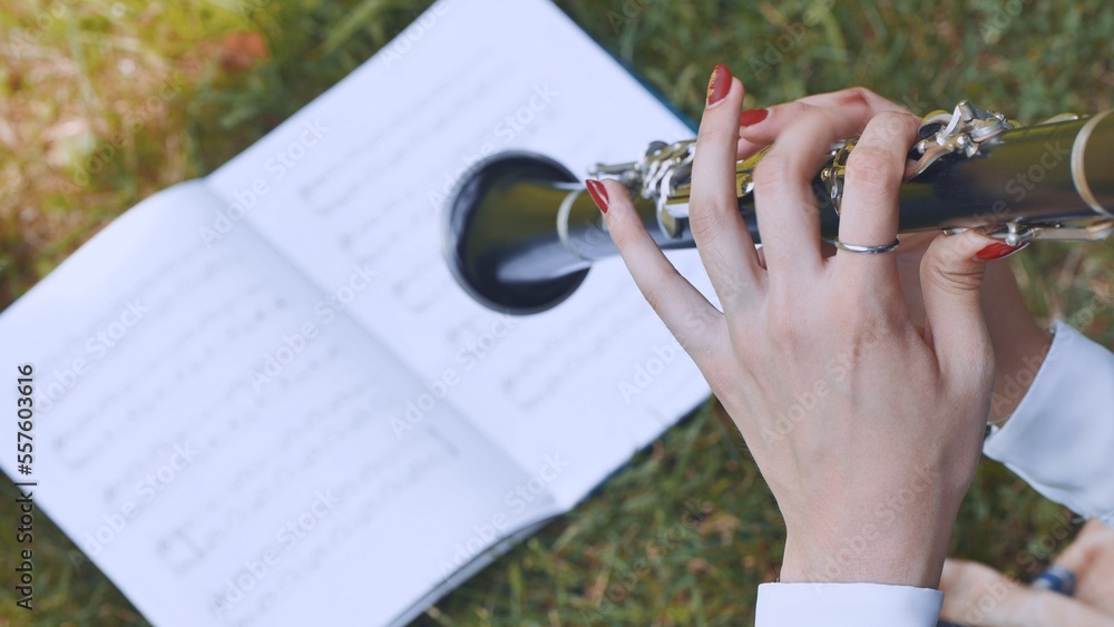 The girl plays the clarinet by notes.