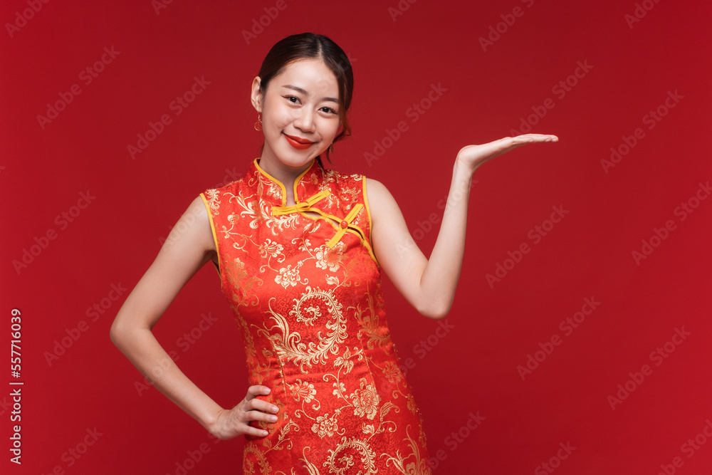 Young asian woman wearing qipao cheongsam dress with product presentation on red background for Chin