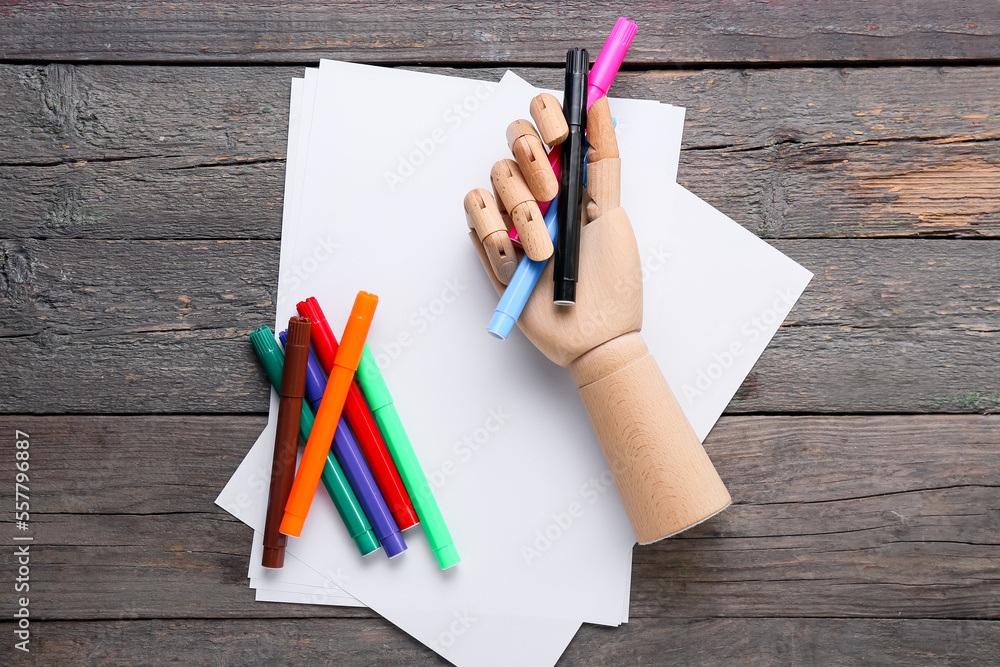 Paper sheets with felt-tip pens and holder on dark wooden background