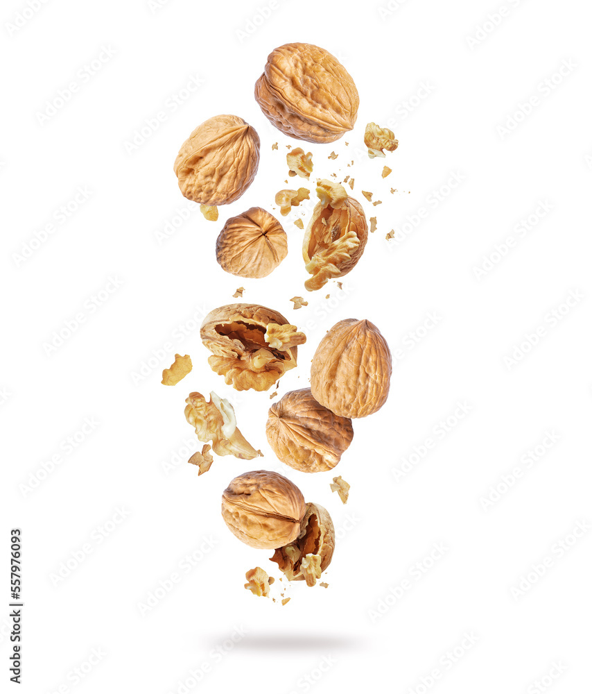 Whole and cracked walnuts close-up in the air on a white background