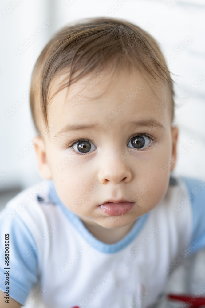 Close-up of sweet little baby face looking at camera. Handsome toddler portrait.