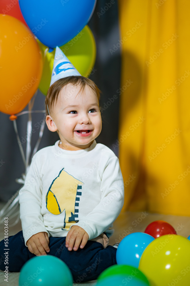 First birthday baby boy party. Happy baby boy with colorful balloons.