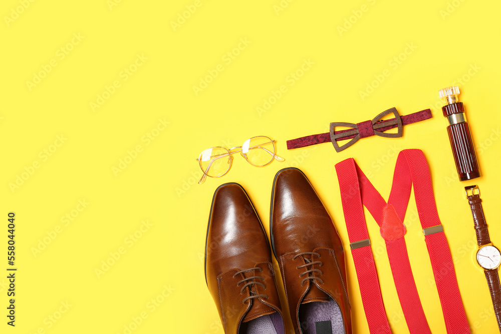 Stylish male accessories and shoes on yellow background