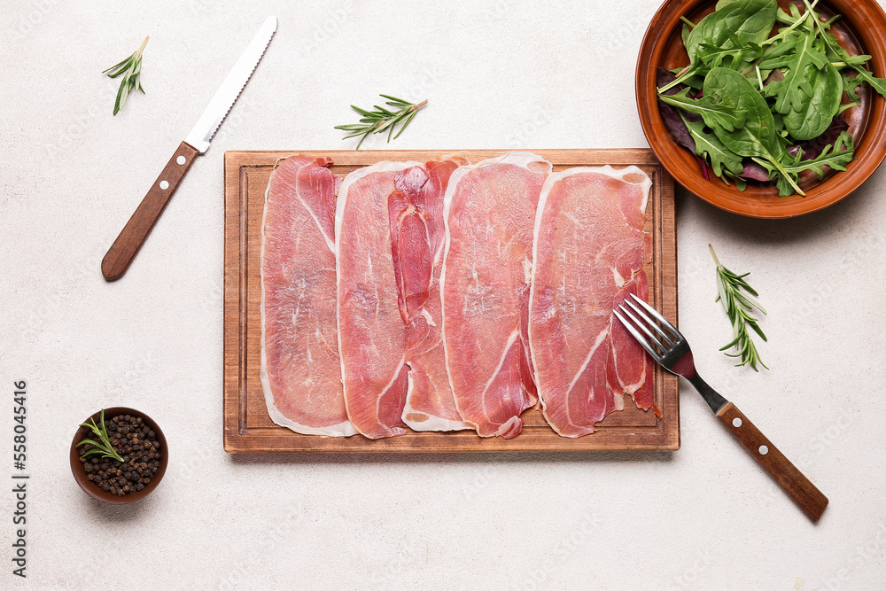 Wooden board with slices of tasty ham, peppercorns and greens on light background