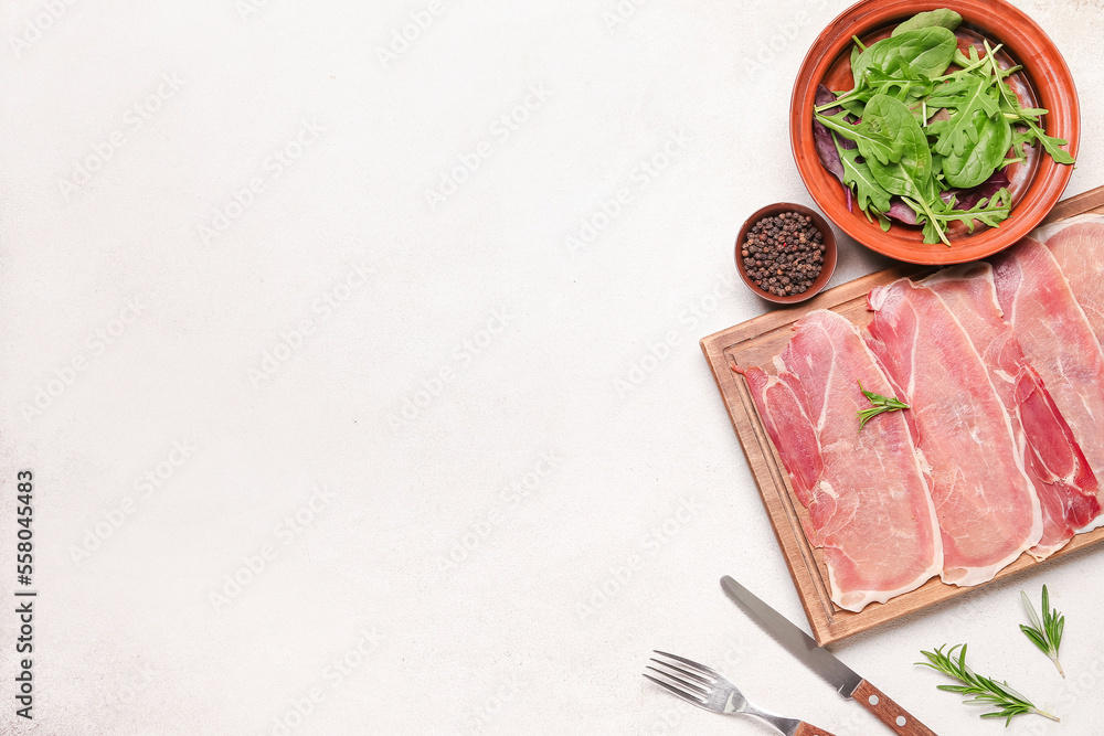 Wooden board with slices of tasty ham, peppercorns and greens on light background