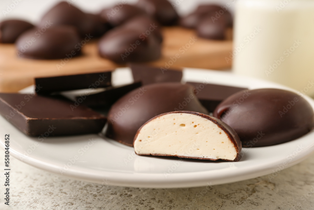 Plate with sweet chocolate birds milk candies, closeup