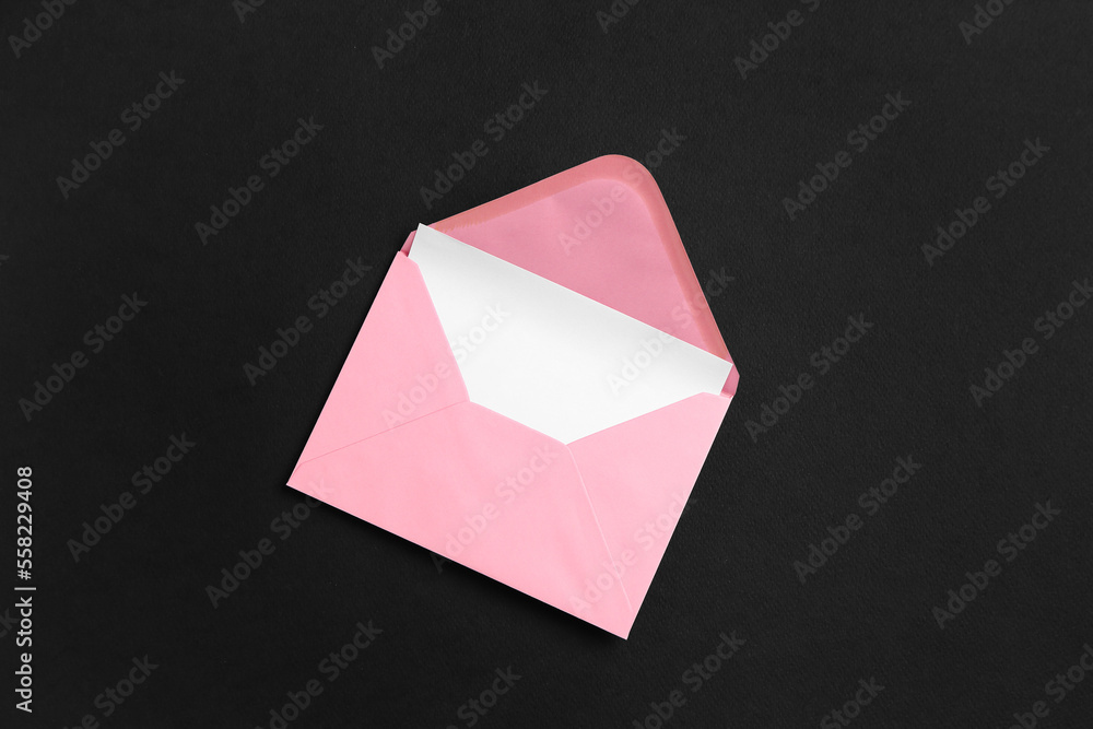 Pink paper envelope with card on dark background