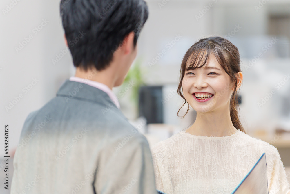 オフィスで立ち話をする若い男女