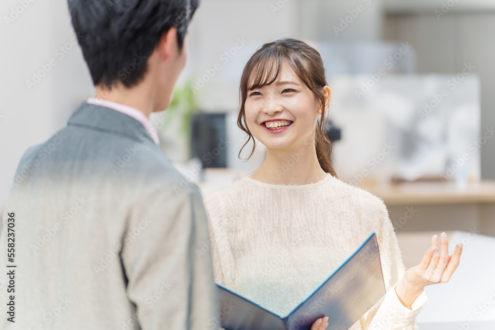 オフィスで立ち話をする若い男女